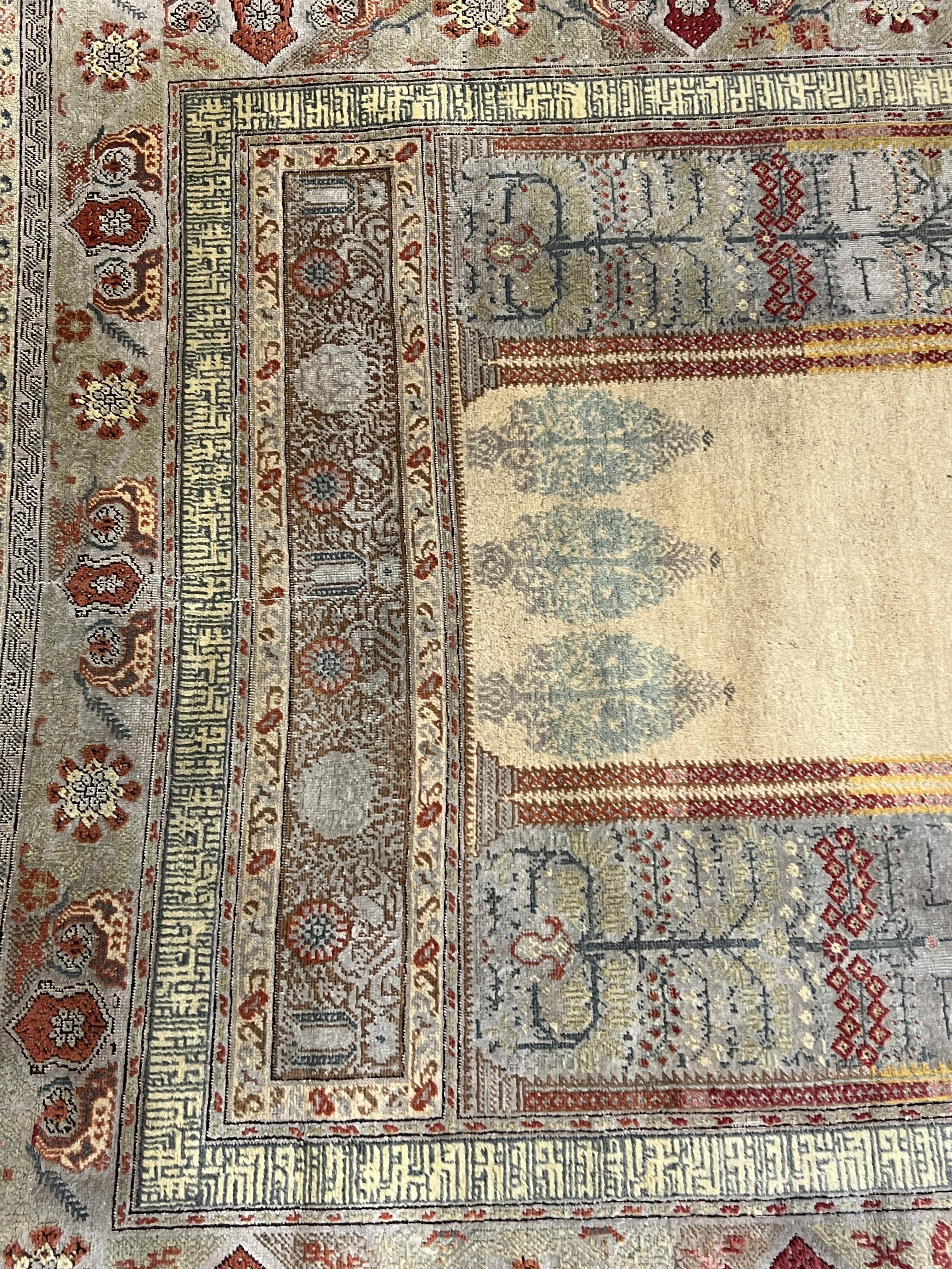 A Turkish silk prayer rug, with central mihrab and stylised floral borders, 205 x 122cm. Condition - worn and faded throughout, all edges worn with a degree of losses.